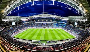 Stadion RB Lipsk, zdjęcie ukazuje obiekt w pełnej krasie, na boisku widać zawodników, a trybuny wypełnione są kibicami,